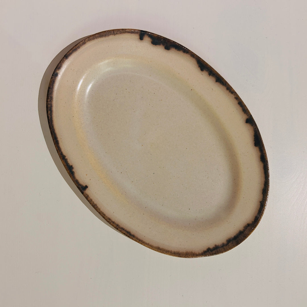 アイボリーベースの茶の線が特徴の楕円皿中