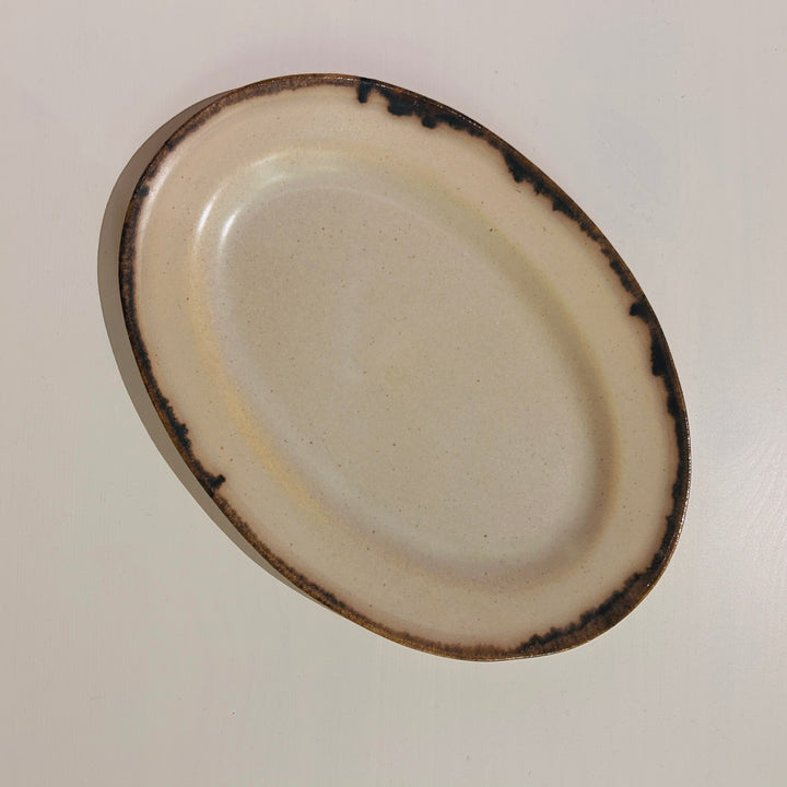 アイボリーベースの茶の線が特徴の楕円皿中