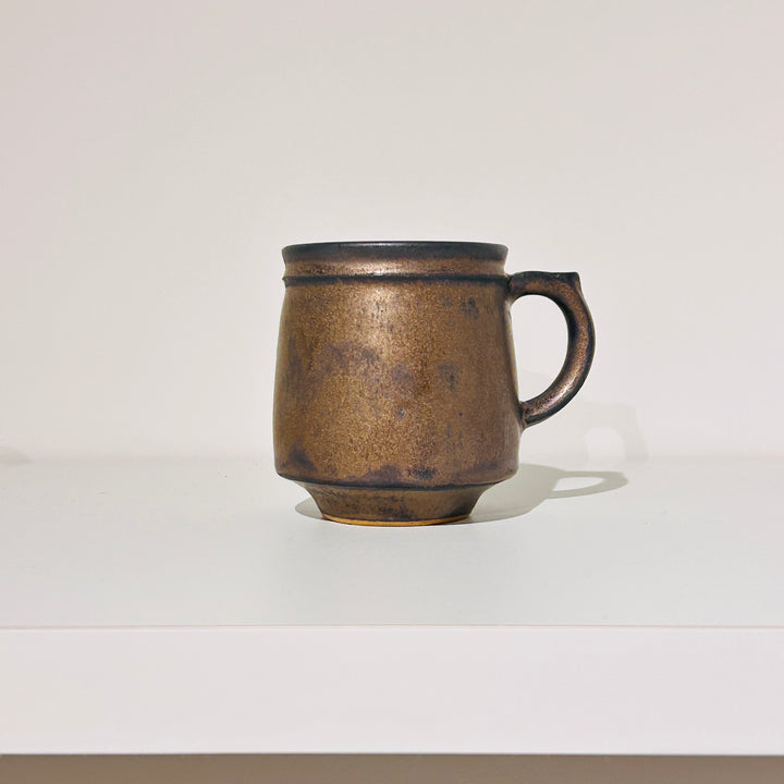 黒色の線が入った茶色の温かみのあるマグ