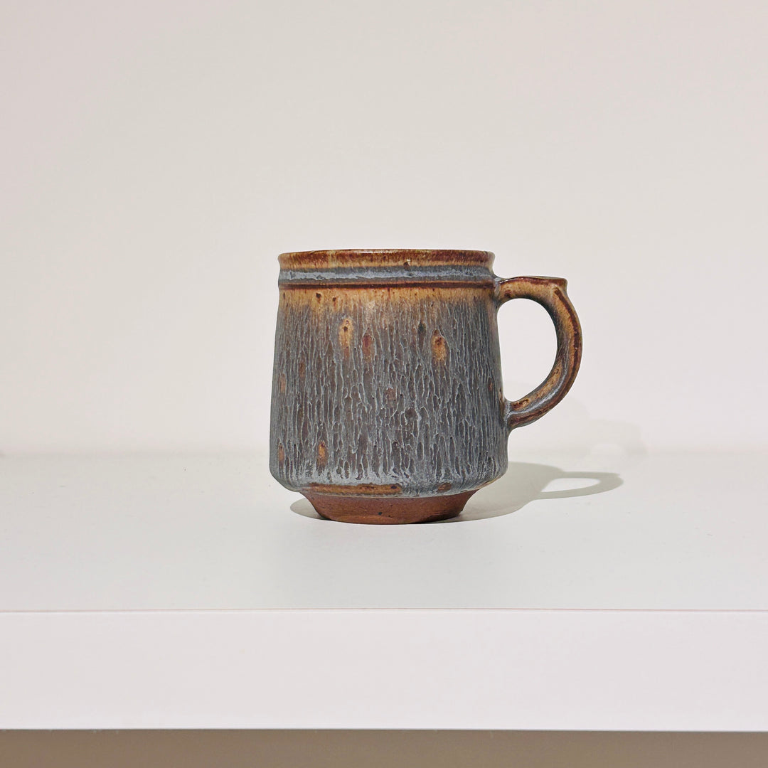 茶色の線が入った青い温かみのあるマグ